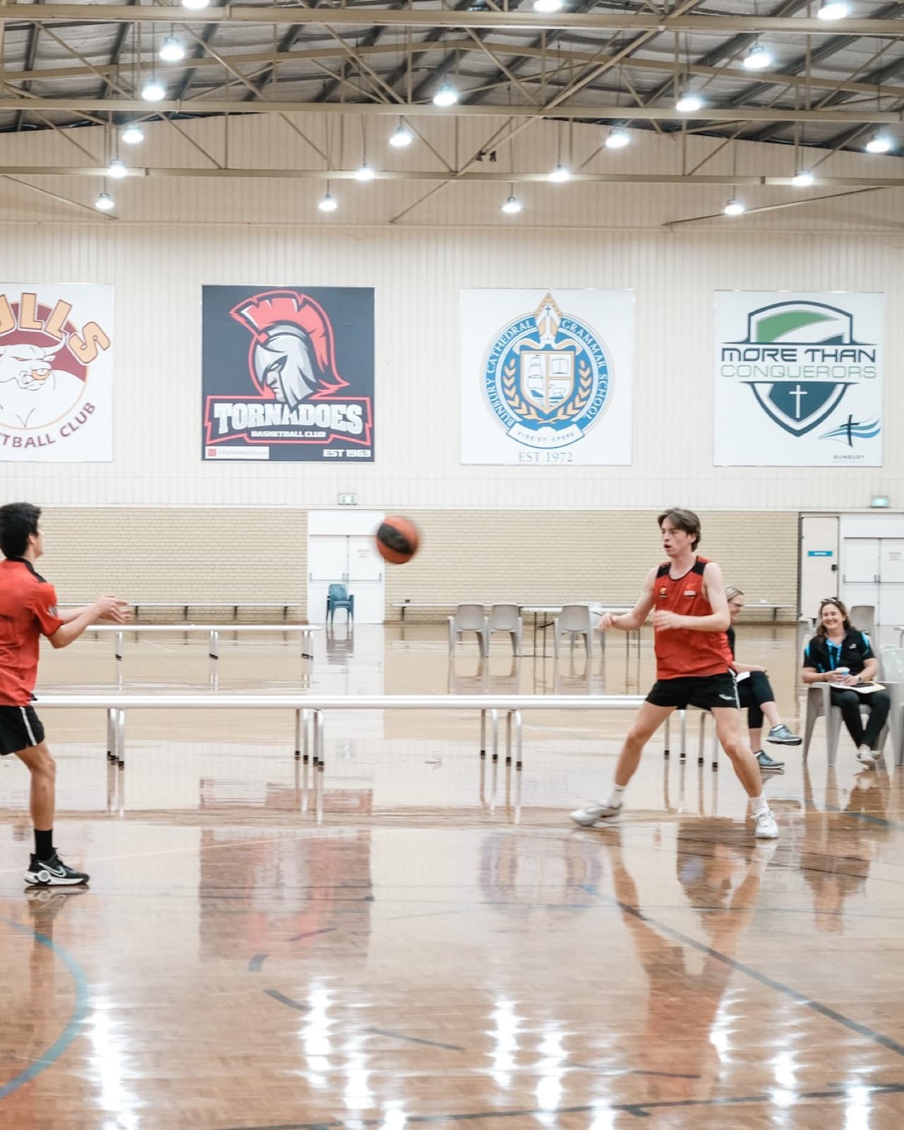 Players on court at the South West Sports Centre in Bunbury, with Bunbury Basketball Association club banners on the wall