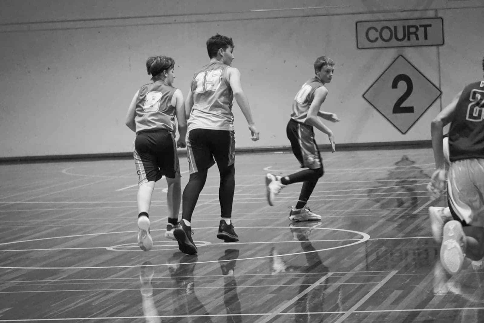 Players running a drill beside Court 2 at an Emerald Basketball Association session