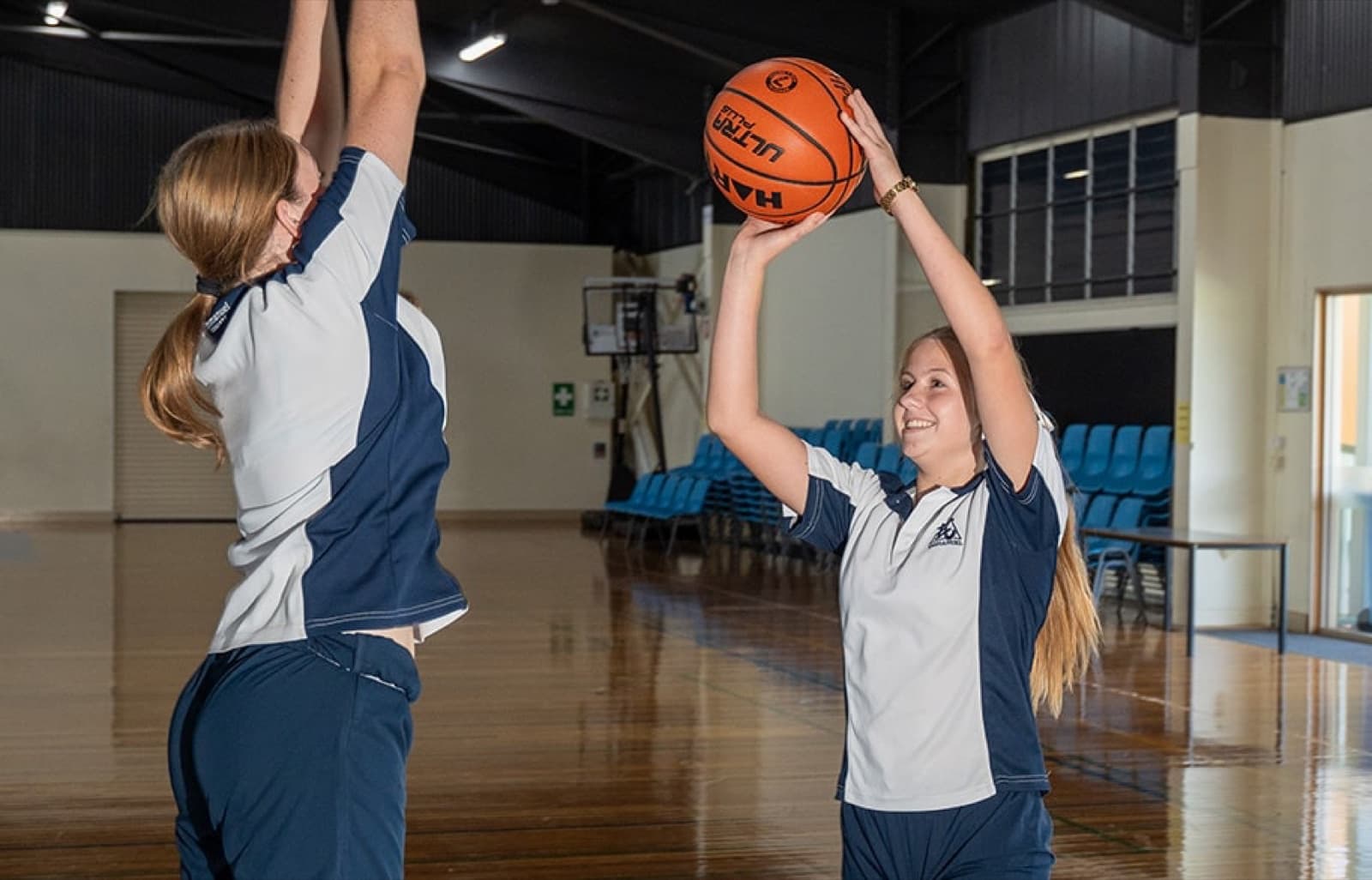 Emmanuel College students playing basketball in the school hall