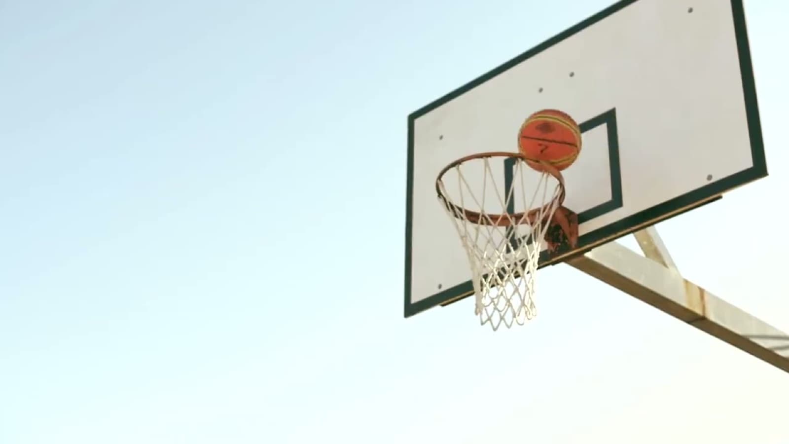 Ball dropping through an outdoor hoop at Emmanuel College