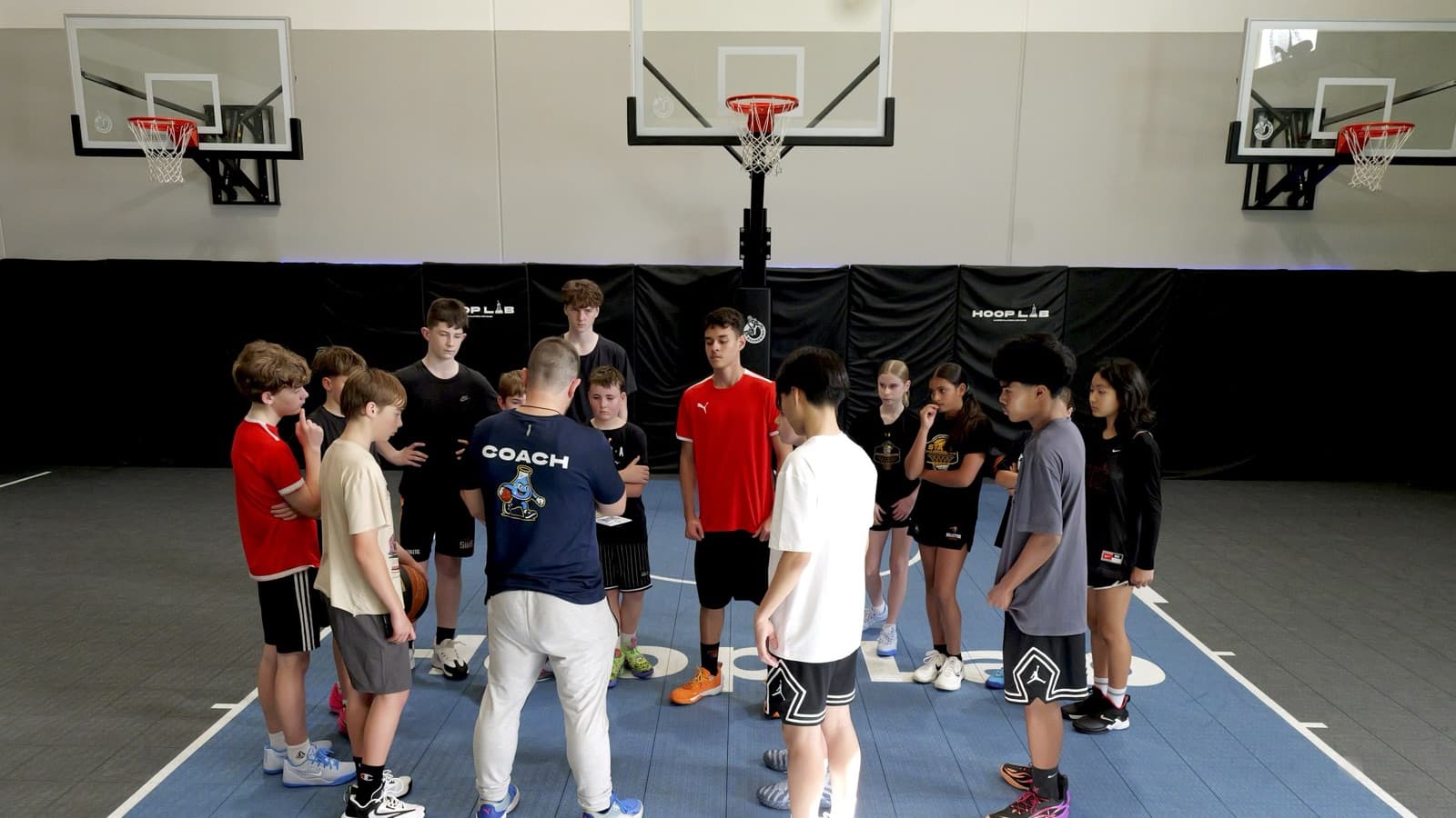 Coach with a group of juniors on court at HoopLab, Malaga